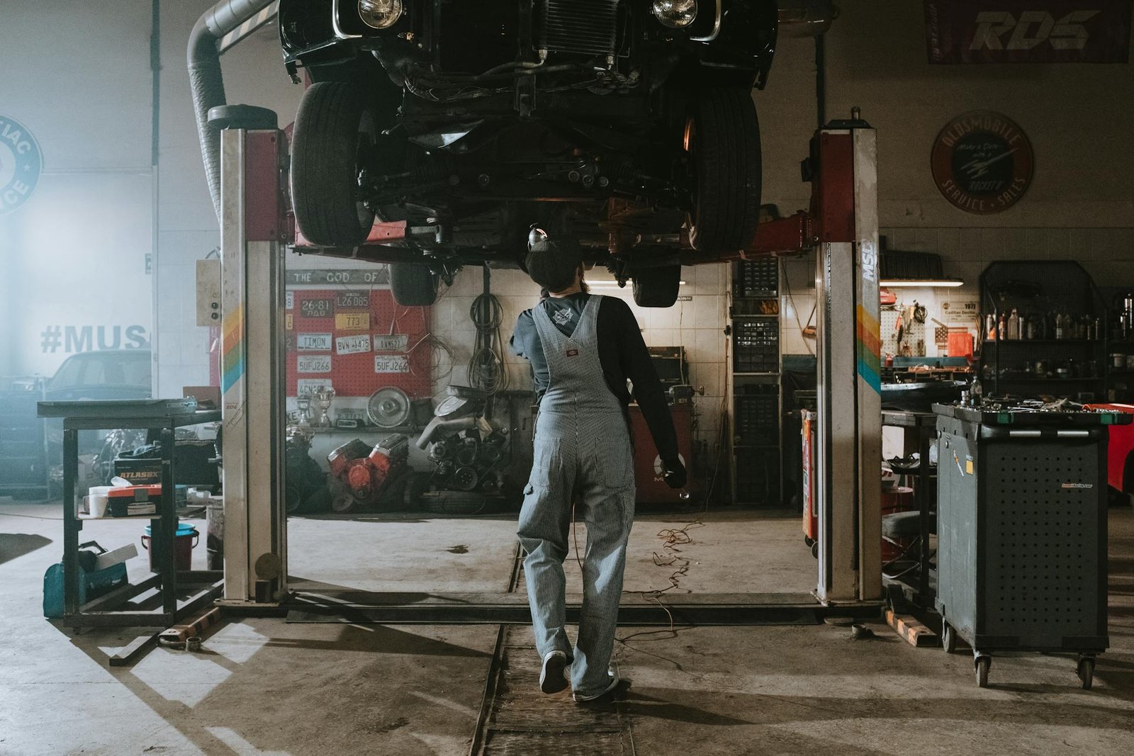 Technician inspecting a vehicle on a lift inside an auto service center